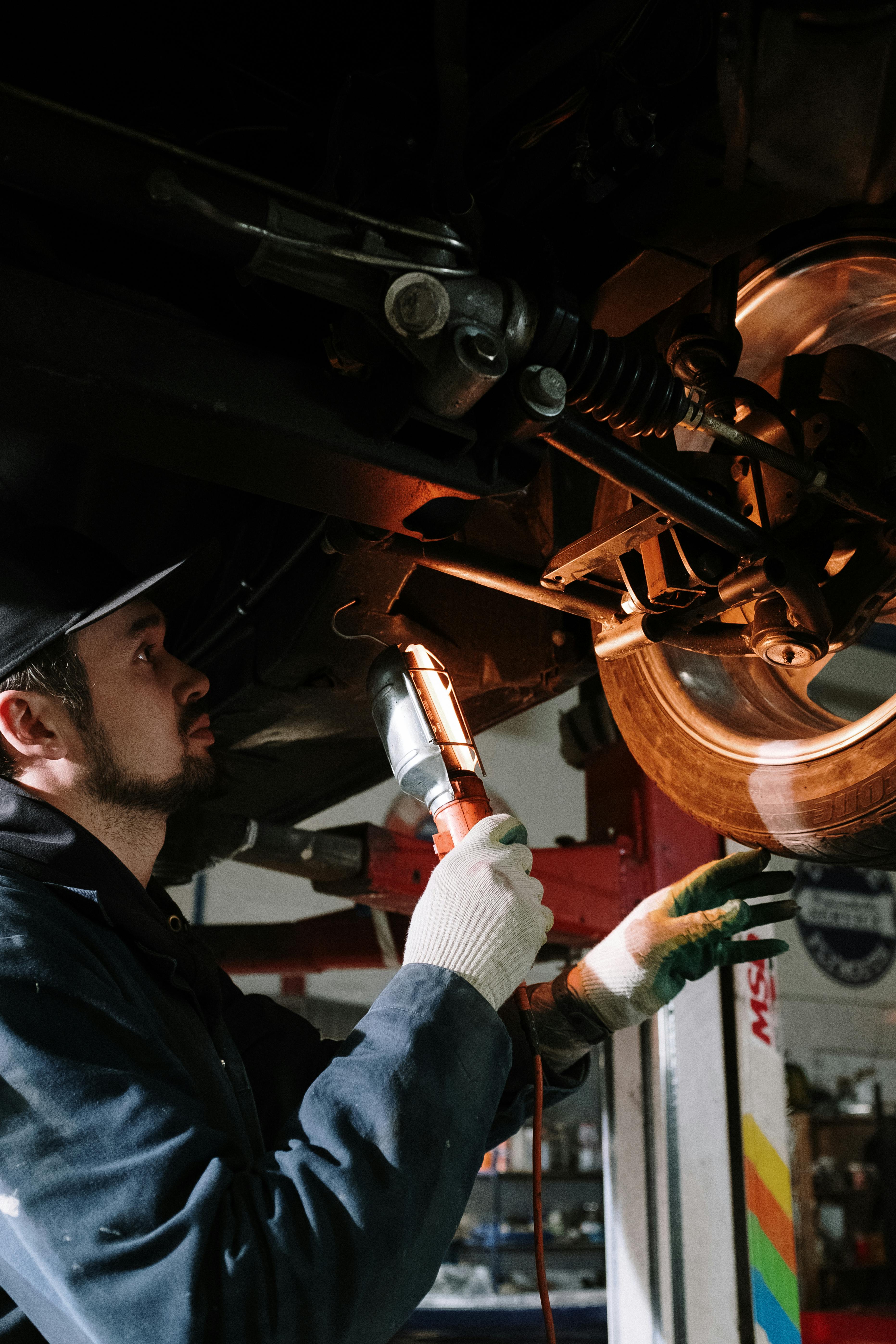 Certified service technician working on a Ford truck in a service bay