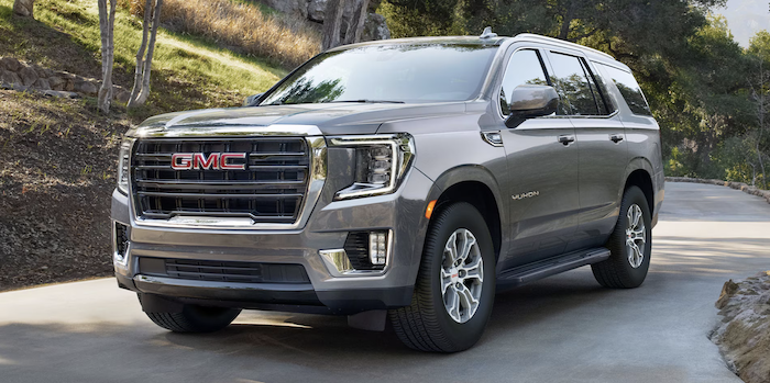Gray 2024 GMC Yukon driving down road