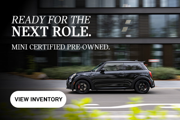 Side view of black MINI 2 Door driving down the road