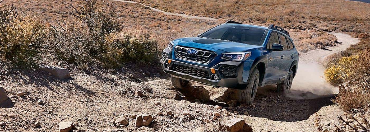 Blue Subaru Outback Wilderness climbing a rocky trail