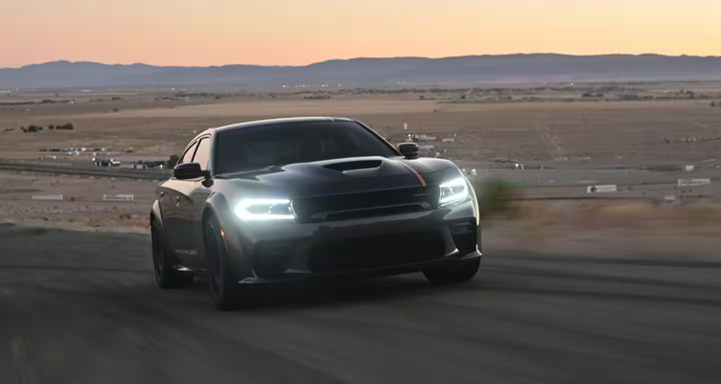 A gray Dodge Charger driving on the road.