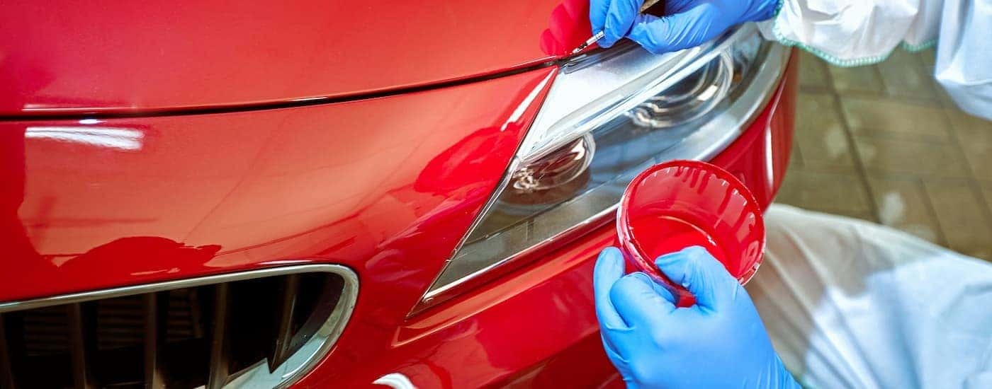 A close up of a person painting a vehicle