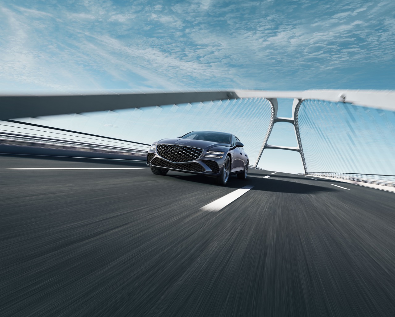 Low 7/8 front driver side view of Genesis G80 in Ceres Blue driving on suspension bridge