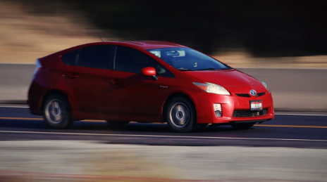 Red Toyota Prius driving down a Kirksville, MO highway.