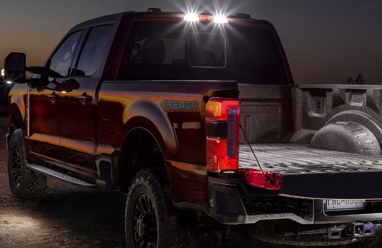 Red 2026 Ford Super Duty Tremor Rear Exterior at Night with Bed Lights