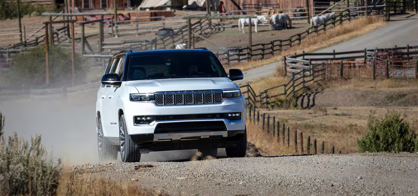 A white suv driving down a road.