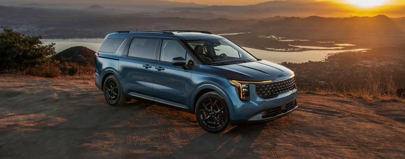 Blue 2026 Kia Carnival parked at an overlook