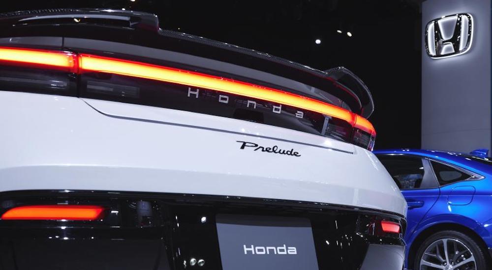 Close-up on the taillights of a white 2026 Honda Prelude parked in a showroom.
