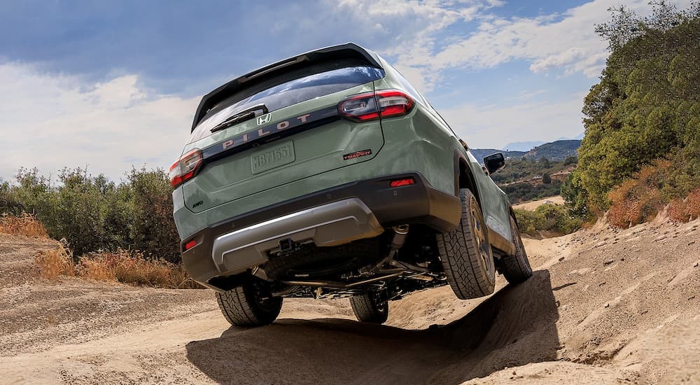 Green 2026 Honda Pilot off-roading on a dirt path
