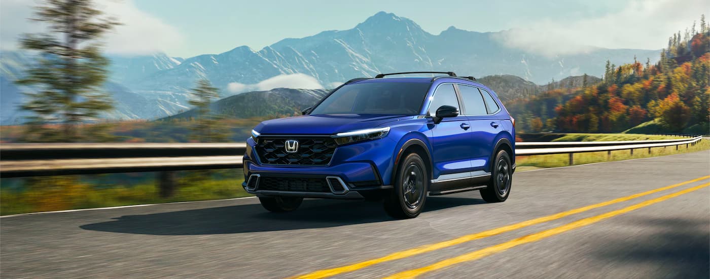 Blue 2024 Honda CR-V driving on a highway