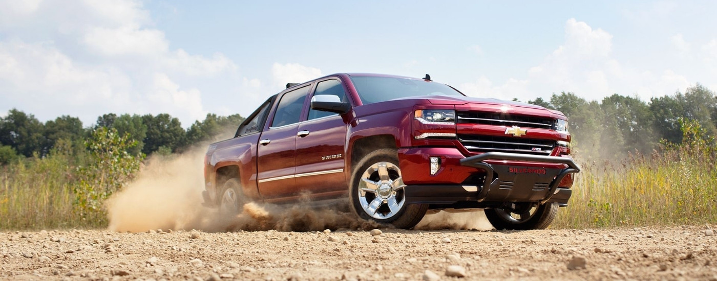 A maroon 2016 Chevy Silverado 1500 Z71 is kicking up dust.