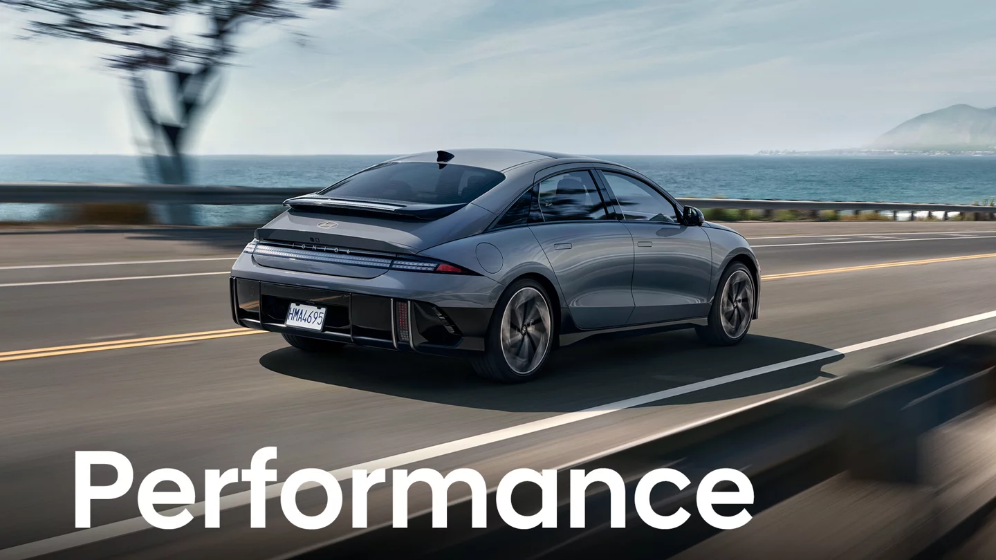 2025 Hyundai IONIQ 6 driving on a highway next to a body of water