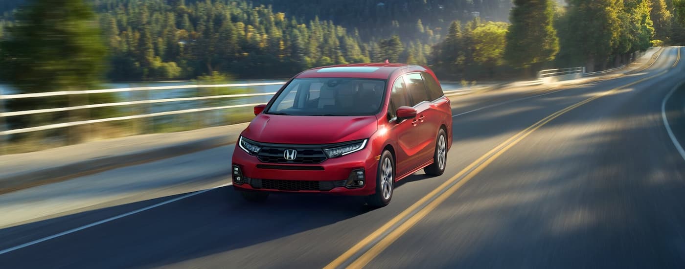 Red 2020 Honda Odyssey driving down an open road.