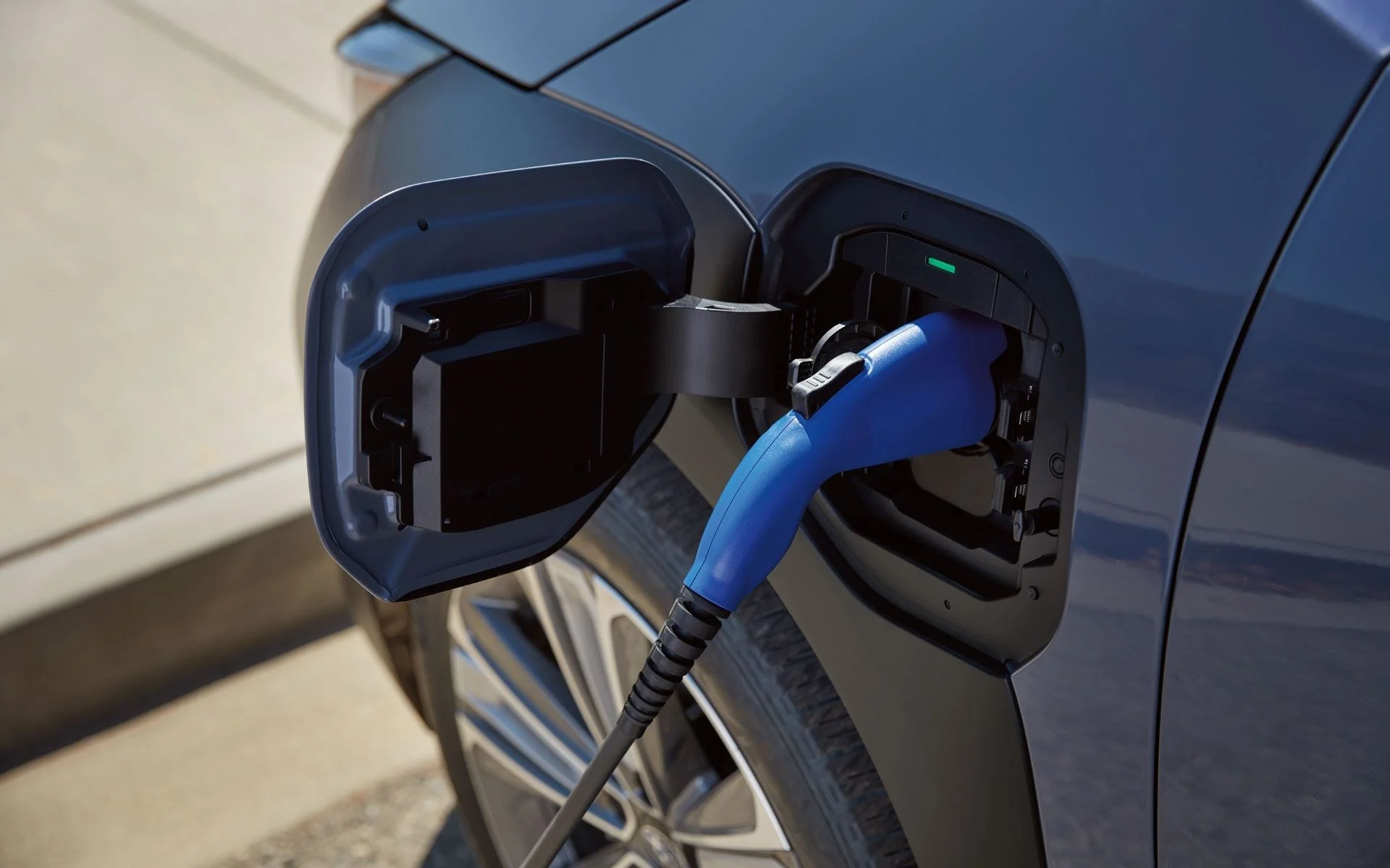 A close-up of a charger plugged into the charging port of a Subaru Solterra.