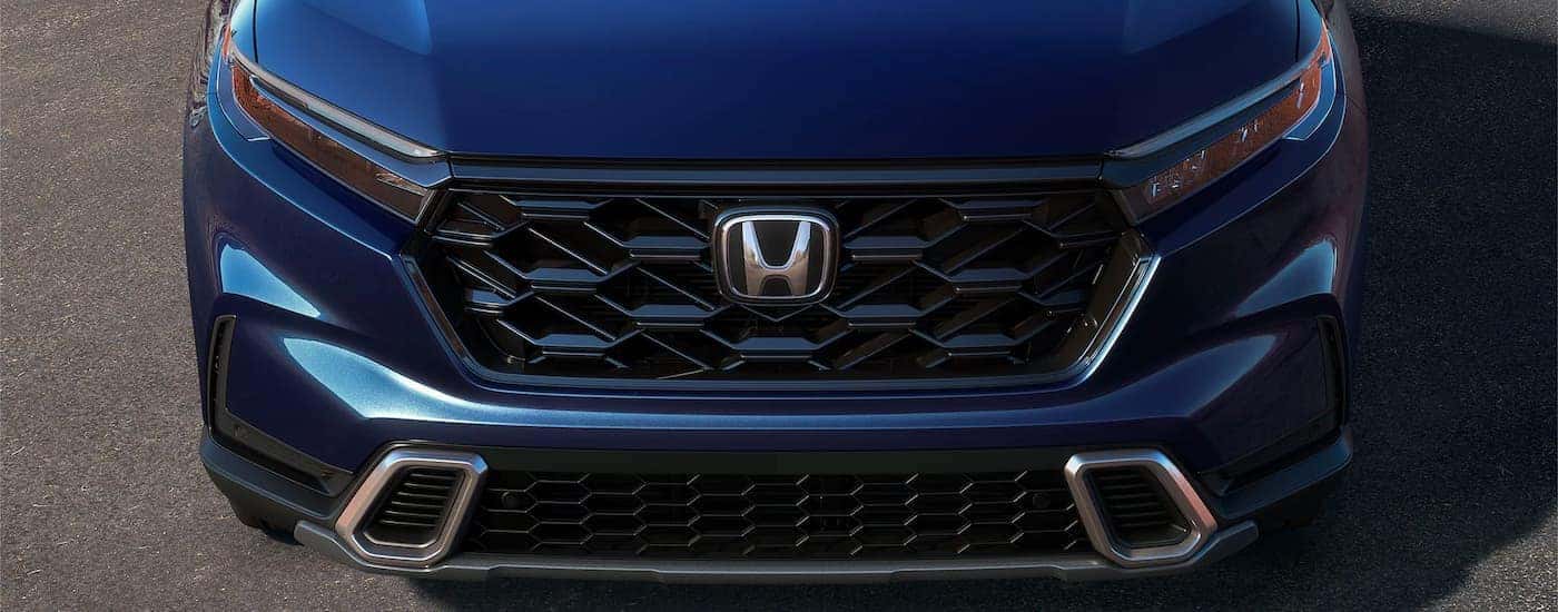 Close-up on the hood of a blue 2024 Honda CR-V Hybrid Sport Touring.