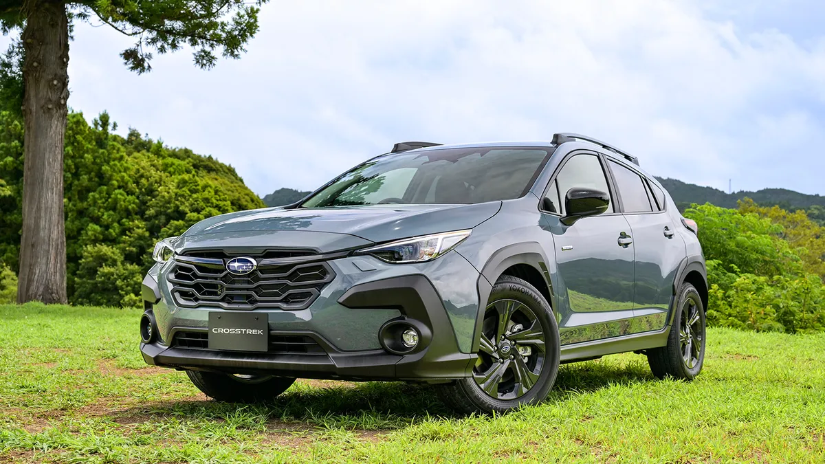 Gray 2024 Subaru Crosstrek parked on grass near tall trees