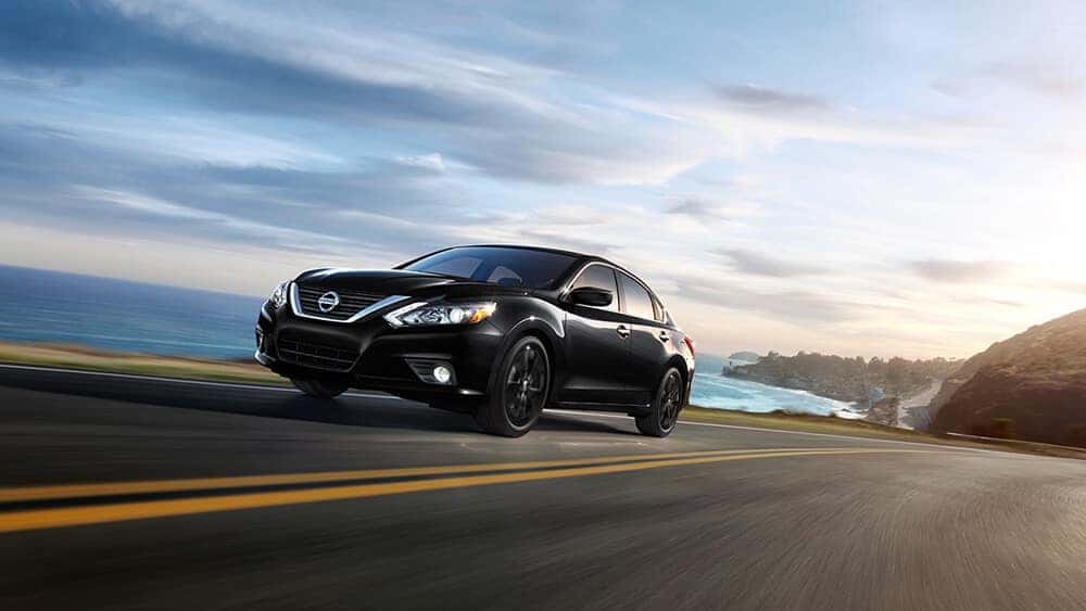 Black 2017 Nissan Altima SR Midnight Edition driving on a coastal road