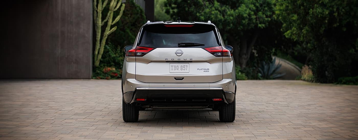 Rear of a tan 2026 Nissan Rogue parked in a driveway