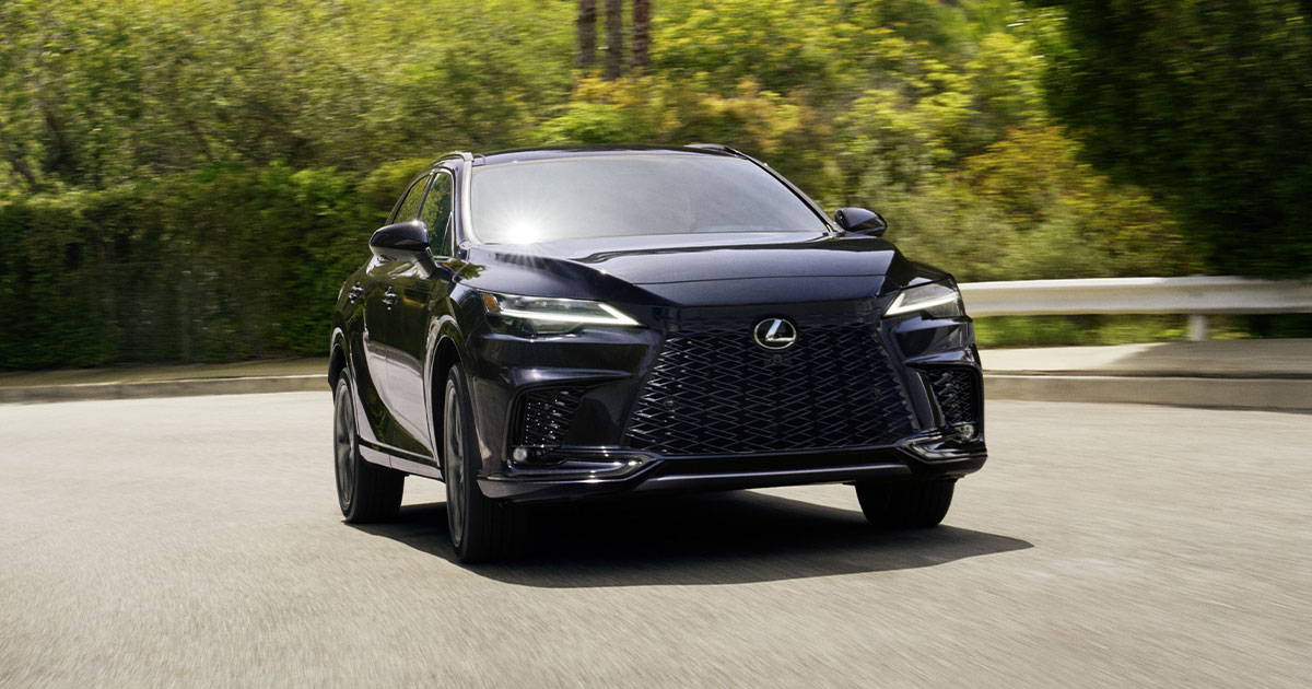 A black Lexus RX driving up a hill.