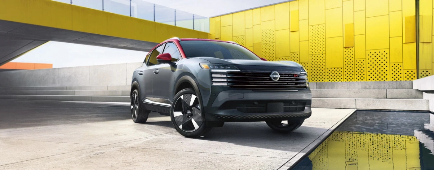 Red and gray 2025 Nissan Kicks parked outside a building