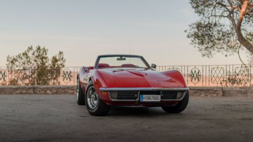 Red Chevrolet Corvette parked at a scenic overlook.