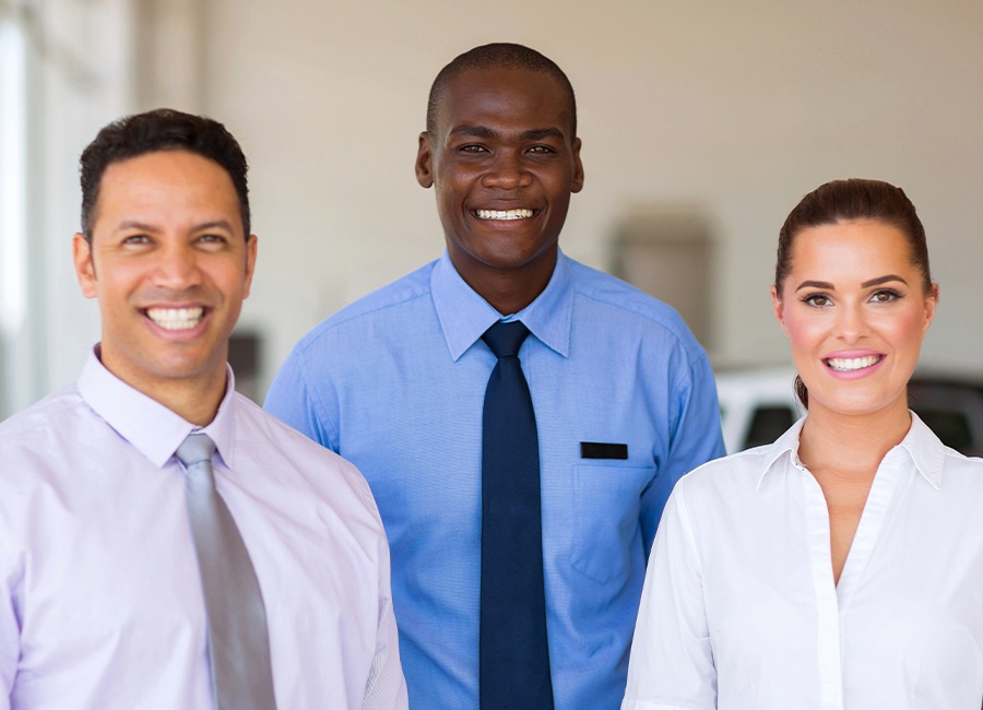 Equipo de ventas sonriente en el concesionario