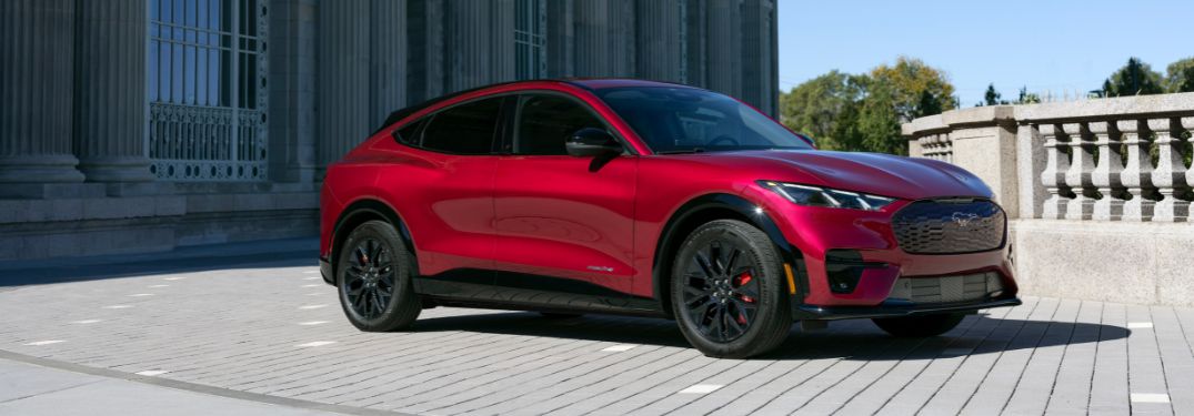 Red 2025 Ford Mustang Mach-E in Front of Fancy Building