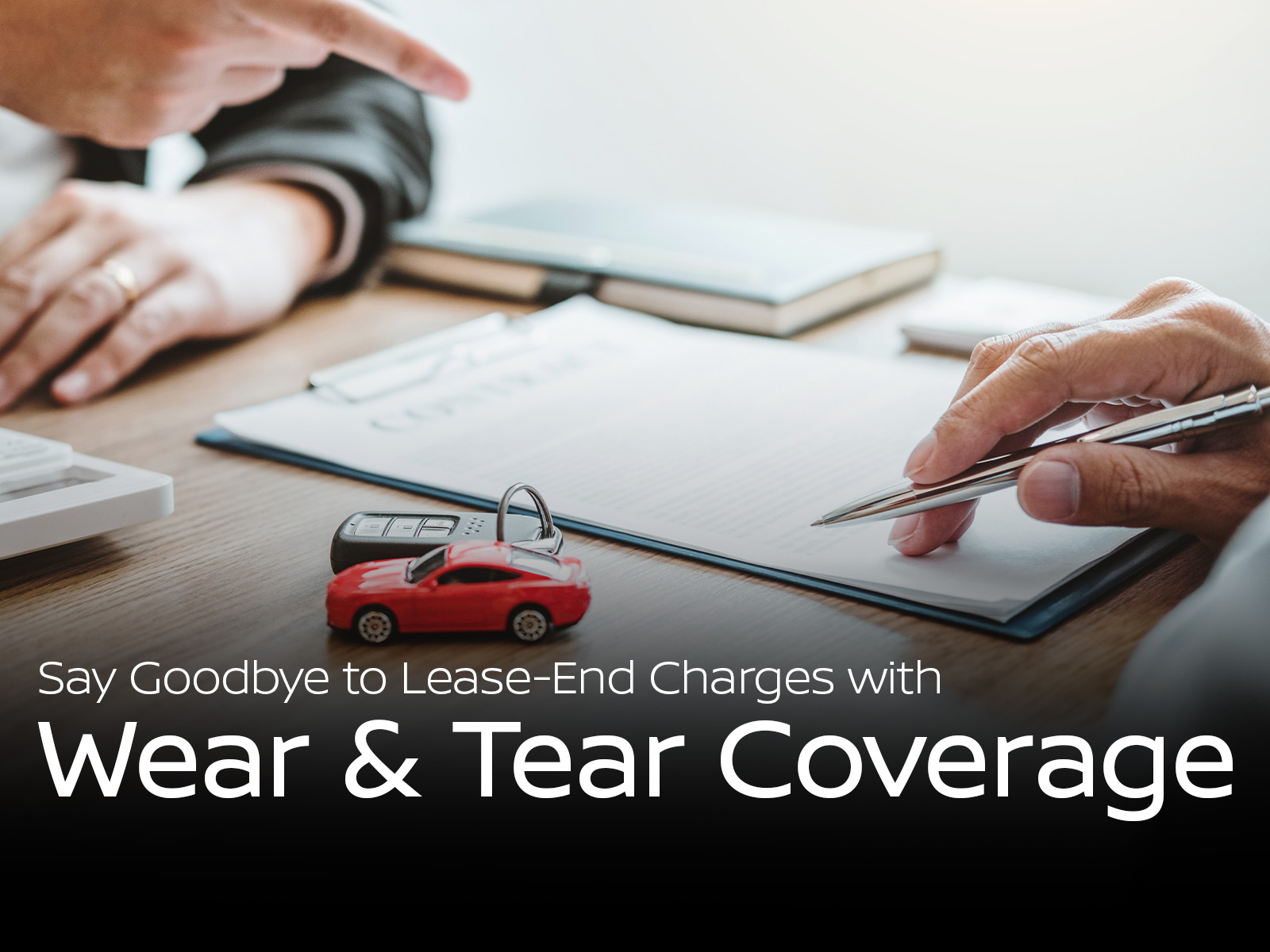 Hands signing lease paperwork at Boulder Nissan – excess wear and tear protection for vehicles leases on ARIYA and more